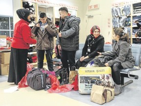 Members of a Syrian refugee family are given new winter coats as they arrive at the Welcome Centre at Toronto?s Pearson Airport last month. (Mark Blinch/Reuters)