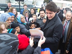 Prime Minister Justin Trudeau greets refugee families who recently arrived in Canada at an open house of the Masjid Al-Salaam Mosque in Peterborough Ont., Sunday, January 17, 2016. THE CANADIAN PRESS/Fred Thornhill