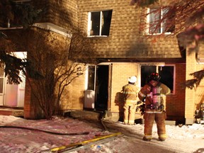 Edmonton fire crews douse hot spots after a fire ripped through a row house near 66 Street and 149 Avenue just before 10 p.m. Friday, Jan. 22, 2016.