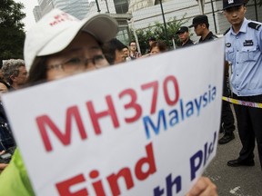 A woman whose relative was aboard Malaysia Airlines flight MH370 holds a placard after police stopped protesting relatives from entering a road leading to the Malaysian embassy in Beijing in this August 7, 2015 file photo. REUTERS/Damir Sagolj