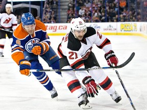 Oilers defenceman Griffin Reinhart chases Devils' Kyle Palmieri during a game in November. Reinhart was recalled from the Bakersfield Condors Friday. (THE CANADIAN PRESS)