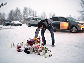 A resident of La Loche, Sask., pays his respects on Saturday January 23, 2016 to the victims of a Friday school shooting. The shooting left four people dead. (THE CANADIAN PRESS/Jason Franson)