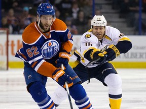 Oilers defenceman Eric Gryba battles the Predators’ Cody Bass during first-period action Saturday at Rexall Place. (David Bloom)
