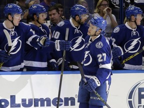 Tampa Bay Lightning left wing Jonathan Drouin (27) celebrates with teammates on the bench after scoring against the Nashville Predators during the third period of an NHL preseason hockey game in Tampa, Fla., on Sept. 22, 2015. (THE CANADIAN PRESS/AP, Chris O'Meara)