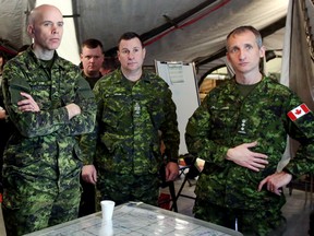 Canadian Armed Forces Brigadier-General Wayne Eyre, Commander of 3rd Canadian Division and Joint Task Force West, left, and 1 Canadian Mechanized Brigade Group (1 CMBG) commander Trevor Cadieu, right receive a briefing during Exercise SENECA RAM  at CFB Edmonton on Tuesday, February 3, 2015  in Edmonton, AB. TREVOR ROBB/EDMONTON SUN
