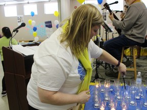 Dana Fallowfield of the Alzheimer Society of Oxford lights candles for the Lights of Hope laps during Ingersoll's Walk for Alzheimer's on Saturday, January 23, 2016. (MEGAN STACEY, Sentinel-Review)