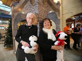 Joyce Gittins (left), and Kai Madsen join at the Tower of Toys for the Christmas Cheer Board at The Forks in Winnipeg at the start of the holiday season. (Winnipeg Sun/Postmedia Network)