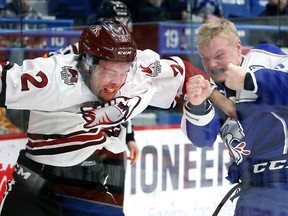 Levi Tetrault of the Guelph Storm and Macauley Carson of the Sudbury Wolves duke it out during first period OHL action in Sudbury, Ont. on Sunday January 24, 2016. Gino Donato/Sudbury Star/Postmedia Network