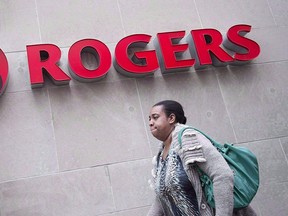 A pedestrian walks past the Rogers Building, in Toronto, on April 22, 2014. THE CANADIAN PRESS/Darren Calabrese