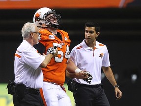 B.C Lions Dean Valli is helped off the field after being injured while playing the Ottawa Redblacks during the first half of their CFL football game in Vancouver, British Columbia, October 11, 2014. (REUTERS/Ben Nelms)