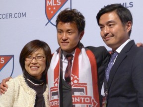 Toronto FC draft choice Tsubasa Endoh, centre, poses for photos with his mother and agent, Takehiko Nakamura, at the MLS SuperDraft in Baltimore on Thursday, Jan. 14, 2016. THE CANADIAN PRESS/Neil Davidson