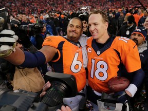 Denver Broncos quarterback Peyton Manning (18) poses for a photo with teammate Ryan Harris following the AFC Championship game against the New England Patriots, Sunday, Jan. 24, 2016, in Denver. (AP Photo/Charlie Riedel)