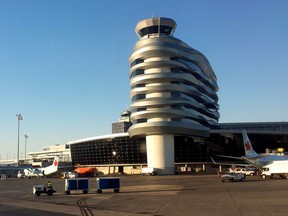 Air Canada planes line-up against the terminal as a baggage handler drives past at the Edmonton International Airport on Sunday evening in Edmonton, Alta., on July 19, 2015. Tom Braid/Postmedia Network