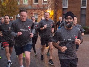 Canadian Defence Minister Harjit Singh Sajjan, right, is followed by former defence minister Peter MacKay, centre, as he leads a five kilometre run on the third day of the Halifax International Security Forum in Halifax on Sunday, Nov. 22, 2015. THE CANADIAN PRESS/Andrew Vaughan