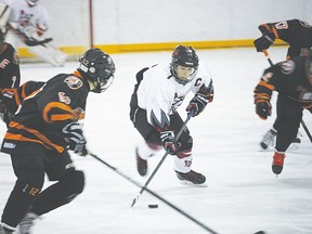 Peewee Hawk Reid Liebreich weaves through Medicine Hat’s defensive players during a game last Saturday at the Vulcan District Arena. Liebreich led the peewee squad to a 5-3 victory against Medicine Hat.