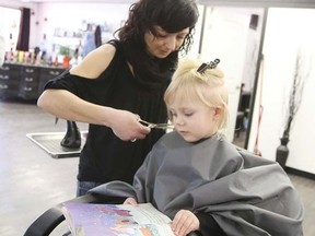 Hailey Brown,3, reads Cinderella at the Tales for Trims event at Mirror Mirror Salon and Spa on Jan. 22. Jocelyn Doll photo/Pincher Creek Echo