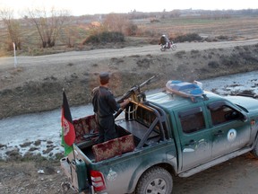 In this Monday, Dec. 28, 2015 photo, Afghan police patrol in Lashkar Gah, capital of Helmand province, Afghanistan. Afghan provincial spokesman says a policeman turned his gun on 10 other officers in an "insider attack" orchestrated by the Taliban. (AP Photos/Abdul Khaliq)