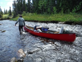 Adam Shoalts pulls his canoe along a shallow river during an expedition to Northern Ontario. Handout/Welland Tribune/Postmedia Network