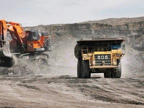 A haul truck carrying a full load drives away from a mining shovel at the Shell Albian Sands oilsands mine near Fort McMurray, Alta., Wednesday, July 9, 2008. Alberta lost more jobs last year than in any year since the 1982 recession, revised numbers from Statistics Canada show. THE CANADIAN PRESS/Jeff McIntosh