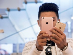 A man takes pictures as the Apple iPhone 6s and 6s Plus go on sale at an Apple Store in Beijing, China, in this Sept. 25, 2015 file photo.  REUTERS/Damir Sagolj/Files