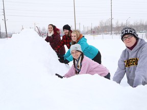 Cambrian College students Mikayla Lebel, left, Ryan Grise, Lauren Oliver, Darlene Benoit and Art and Design instructor Johanna Westby create a dragon snow sculpture  on the baseball diamond at the college in Sudbury, Ont. on Tuesday January 26, 2016. John Lappa/Sudbury Star/Postmedia Network