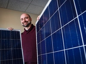 Curtis Buxton, a project manager at Skyfire Energy Inc., who was forced to look for new employment after being downsized out of the oil and gas industry, poses with solar panels, in Calgary on Monday, Jan. 25, 2016.THE CANADIAN PRESS/Jeff McIntosh
