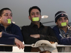 Yellow Taxi drivers (left to right) Gurvinder Saggy, Harjinder Badesha, Anil Prasher and Inklab Aulakh tape their mouths shut while attending Edmonton City Council meeting January 26, 2016. Angry Edmonton taxi drivers disrupted the meeting and were ejected from Edmonton City Council Chambers where city council was having a meeting on the Uber taxi dispute. (LARRY WONG PHOTO)