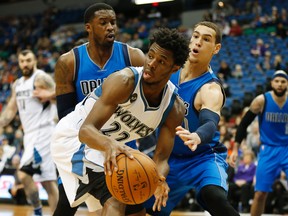 Timberwolves forward Andrew Wiggins (22) looks to pass the ball away from Mavericks forward Dwight Powell (7) during NBA action in Minneapolis on Sunday, Jan. 10, 2016. (Stacy Bengs/AP Photo)