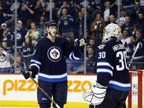 Winnipeg Jets defenseman Tyler Myers (57) celebrates his teams win over the Arizona Coyotes with teammate Winnipeg Jets goalie Connor Hellebuyck (30) after the third period at MTS Centre. Winnipeg won 5-2.