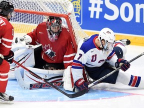 The net tips over Canada’s Mason McDonald as the United States’ Matthew Tkachuk (7) gets caught up during preliminary action at the World Junior Championship in Helsinki on Saturday, Dec. 26, 2015. (THE CANADIAN PRESS/Sean Kilpatrick)