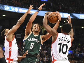 Milwaukee Bucks guard Michael Carter-Williams (5) plays for a rebound with Toronto Raptors guards Kyle Lowry (left) and DeMar DeRozan Nov. 1, 2015 at the Air Canada Centre in Toronto. (Dan Hamilton/USA TODAY Sports)