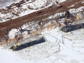 In this aerial photo, crews work the scene of a train derailment Wednesday, Jan. 27, 2016, along Hwy. 26 south of Brownsville, Minn. Authorities say two of six derailed train cars have broken through the ice on the Mississippi River in southeastern Minnesota. (Erik Daily/La Crosse Tribune via AP)