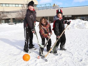 David Barber, 12, left, Daniel Barber, 10, and Braedon Jeanveau, 11, take part in a game of shinny outside Tom Davies Square in Sudbury, Ont. to help launch the Healthy Kids Community Challenge on Wednesday January 27, 2016. John Lappa/Sudbury Star/Postmedia Network