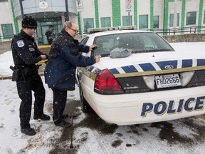Dan Smith, 65, is searched against a police cruiser by an officer at the Gatineau Police Station after refusing to pay a fine and court costs after being found guilty last summer for not having a license for a cat. Thursday January 28, 2016. Errol McGihon/Ottawa Sun/Postmedia Network