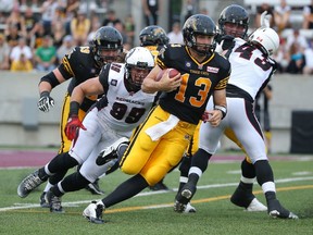 Dan LeFevour of the Hamilton Tiger-Cats carries the ball for a gain during CFL game action against the Ottawa Redblacks at Roy Joyce Stadium in Hamilton on July 26, 2014. (Tom Szczerbowski/Getty Images/AFP)