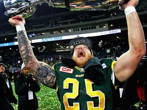 Edmonton Eskimos #25 Mike Miller hoists the Grey Cup after winning the game th.  Sunday, November 29, 2015. (Postmedia Network)