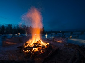 A fire burns as it thaws the frozen ground in order to dig a grave for one of the shooting victims at the cemetery in La Loche, Saskatchewan, Monday, Jan. 25, 2016. A 17-year-old was charged with first-degree murder and attempted murder in a mass shooting at a school and home in the remote aboriginal community in western Canada on Friday, officials said. Jonathan Hayward/The Canadian Press