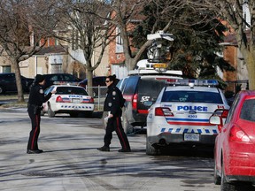 Police officers begin a canvass of the neighbourhood on Milldock Drive in Scarborough where a badly injured man was found on the roadway with no obvious cause on Friday January 29, 2016. Michael Peake/Toronto Sun/Postmedia Network