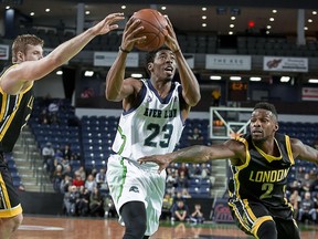 Niagara River Lions' Marcus Lewis finds a hole between London Lightning's Chad Posthumus (20) and Nick Okorie (2) during NBL action at the Meridian Centre on Thursday night. (Colin Dewar, Special to Postmedia Network)