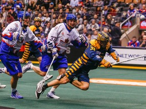 David Earl of the Georgia Swarm (right) falls as Brodie Merrill of the Toronto Rock (centre) tries to retrieve a loose ball during. The Swarm defeated the Rock 20-17. (Dave Thomas/Toronto Sun)