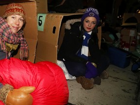 Jason Miller/The Intelligencer
Tanya Dutton (left) and Jerrica Gallinger hide from a frigid Friday night in their makeshift home made of cardboard boxes, sleeping bags and blankets. The two Loyalist College students were among dozens who converged at Market Square for the Sleep Out So Others Can Sleep In event staged by Canadian Mental Health Association Hastings and Prince Edward County branch (CMHA-HPE). The event has raised more than $120,000 in under a decade. Funds raised go to keeping the lights on in four area transitional homes. See more about this event in Monday’s Intelligencer.