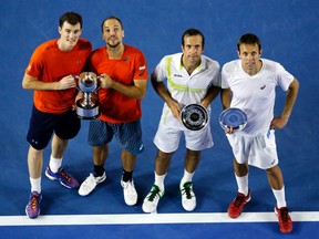 Jamie Murray, left, of Britain and Bruno Soares of Brazil pose with their trophy after defeating Daniel Nestor, right, of Canada and Radek Stepanek, second right, of the Czech Republic in the men's doubles final at the Australian Open in Melbourne, Australia, early Sunday, Jan. 31, 2016. (Vincent Thian/AP Photo)