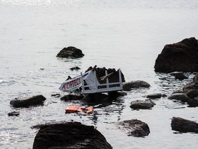Remains of a boat that was carrying migrants seen on the shoreline near the Aegean town of Ayvacik, Canakkale, Turkey, Saturday, Jan. 30, 2016. A boat carrying migrants to Greece hit rocks off the Turkish coast on Saturday and capsized, killing at least 33 people, including five children, officials and news reports said.  Some 75 other migrants were rescued. A Turkish government official said he expects the death toll from the incident to rise as rescue workers try to reach other migrants believed trapped inside the wreckage of the boat which sank shortly after departing from the Aegean resort of Ayvacik.(AP Photo/Halit Onur Sandal)