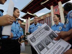 In this Jan. 28, 2016 photo, Westminster teenage police volunteers fan out along the strip of Vietnamese restaurants and shops known as "Little Saigon" to tell storekeepers about the escaped inmates and urge them to post fliers with their pictures to spread the word in Westminster, Calif.  The country's largest Vietnamese enclave is preparing for the annual new year celebration as authorities say at least two fugitives who broke out of jail last week could be hiding in their midst. Authorities say two of the men have ties to Vietnamese gangs and could be hiding nearby. (AP Photo/Damian Dovarganes)
