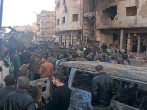 Residents and soldiers loyal to Syria's President Bashar al-Assad inspect damage after a suicide attack in Sayeda Zeinab, a district of southern Damascus, Syria January 31, 2016. At least 60 people were killed, including 25 Shi'ite fighters, and dozens wounded on Sunday by a car bomb and two suicide bombers in the district of Damascus where Syria's holiest Shi'ite shrine is located, a monitor said. Sunni fundamentalist Islamic State claimed responsibility for the attacks, according to Amaq, a news agency that supports the group. REUTERS/Stringer