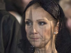 Celine Dion watches the casket of her late husband Rene Angelil's taken away following his funeral at Notre-Dame Basilica in Montreal on January 22, 2016. Just weeks after Dion lost her husband Rene Angelil and older brother Daniel to cancer, the pop superstar will soon return to work. THE CANADIAN PRESS/Paul Chiasson