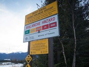 A vehicle passes a sign showing an avalanche hazard warning of "considerable" at a parking lot where snowmobilers embark from near Mount Renshaw outside of McBride, B.C., on Saturday January 30, 2016. Five snowmobilers died Friday in a major avalanche in the Renshaw area east of McBride. THE CANADIAN PRESS/Darryl Dyck