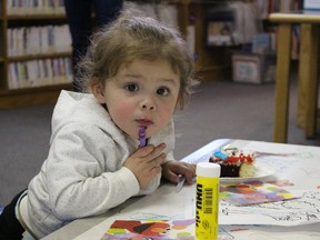Autumn Maness, 1, of Sarnia, takes a break from colouring for a slice of cake at the downtown Sarnia library branch Saturday. Local families packed the children's department for an afternoon of free activities organized by the Canadian Families and Corrections Network. The Kingston-based advocacy group supports families impacted by crime with a variety of resources. Barbara Simpson/Sarnia Observer/Postmedia Network