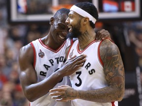 Toronto Raptors center Bismack Biyombo (8) shares a laugh with forward James Johnson (3) against the Detroit Pistons at Air Canada Centre. The Raptors beat the Pistons 111-107. Tom Szczerbowski-USA TODAY Sports