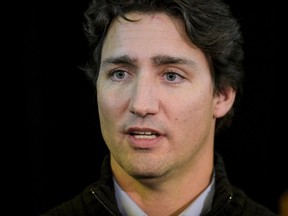 Canada's Prime Minister Justin Trudeau speaks to the press with members of the community including interim Mayor Kevin Janvier and former Mayor and MP Georgina Jolibois, during a visit to the town of La Loche, Saskatchewan January 29, 2016. Trudeau's visit comes a week after a shooter killed four people and wounded seven at a home and high school and a day before funerals were to begin in the isolated aboriginal Saskatchewan town. REUTERS/Matthew Smith